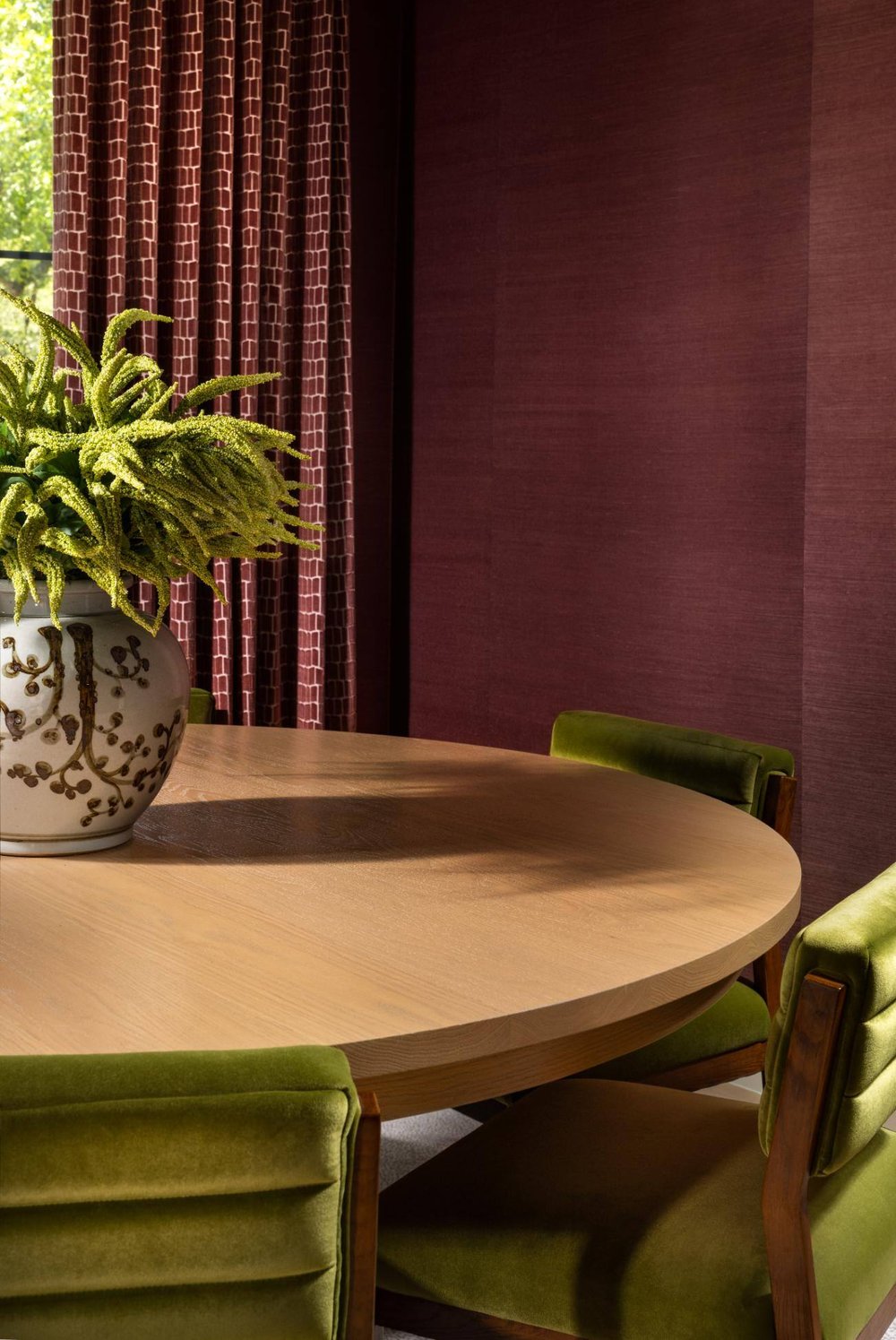 Close-up of a round dining table with a floral vase centerpiece, custom home by Sardone  McClain in Dallas, Texas.