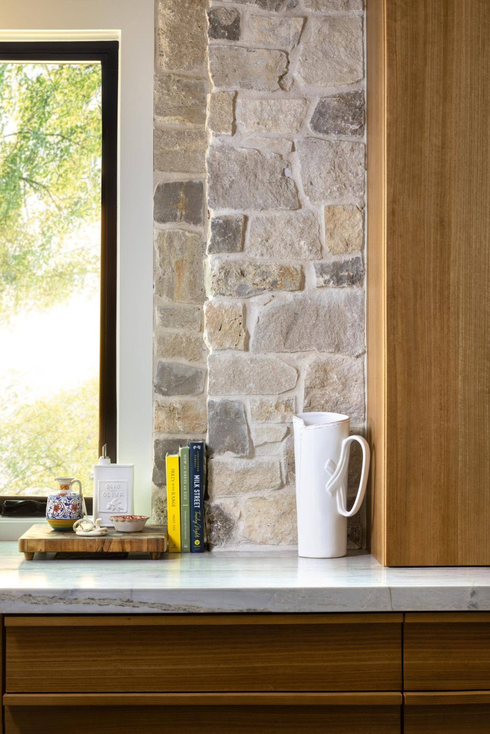 Close-up of kitchen countertop with decorative items and a stone backsplash, custom home by Sardone  McClain in Dallas, Texas