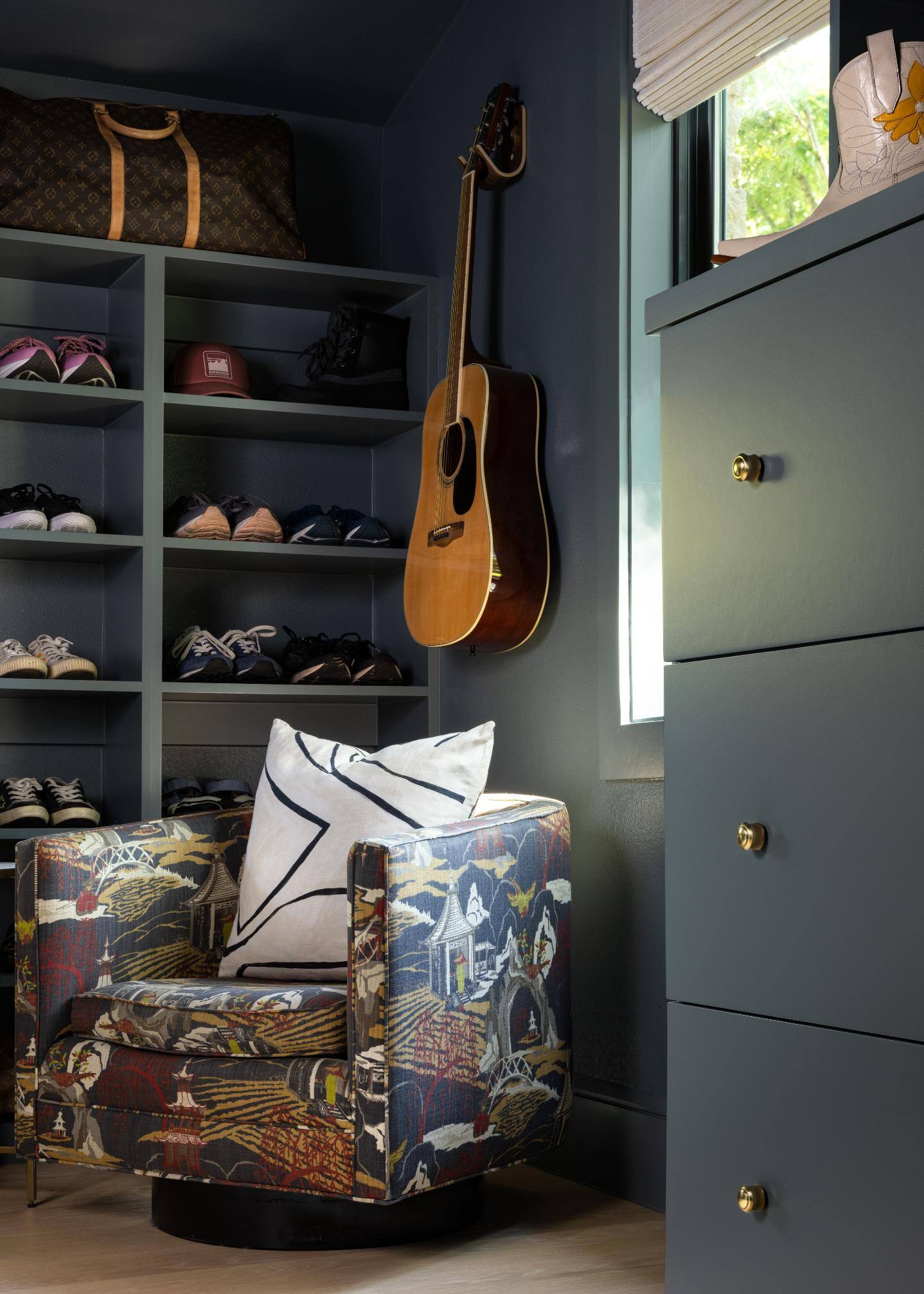 Closet corner with a patterned armchair and guitar display, custom home by Sardone  McClain in Dallas, Texas