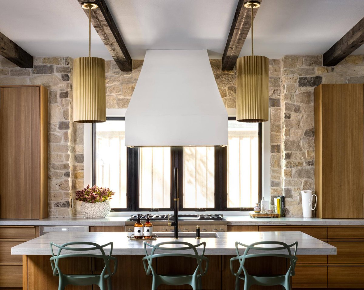 Contemporary kitchen featuring wood cabinets and a central island with seating, custom home by Sardone  McClain in Dallas, Texas.