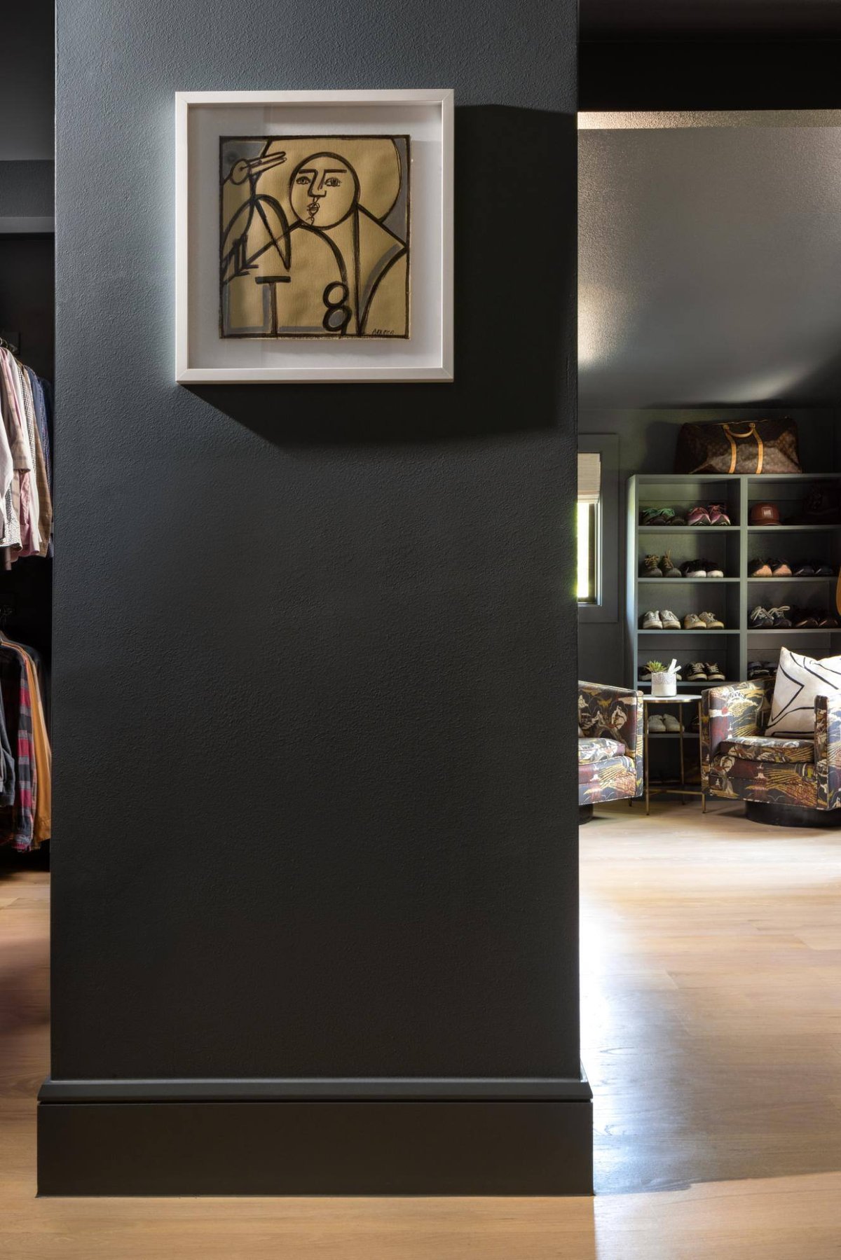 Interior view of a modern walk-in closet with an art piece on the wall, custom home by Sardone  McClain in Dallas, Texas