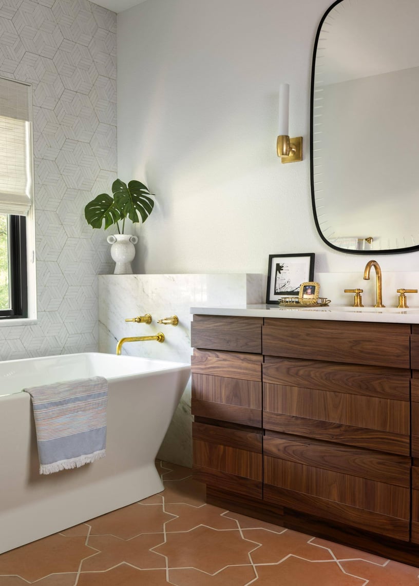 Luxurious bathroom in a custom home remodel with a freestanding tub and gold fixtures, custom home by Sardone McClain in Dallas, Texas