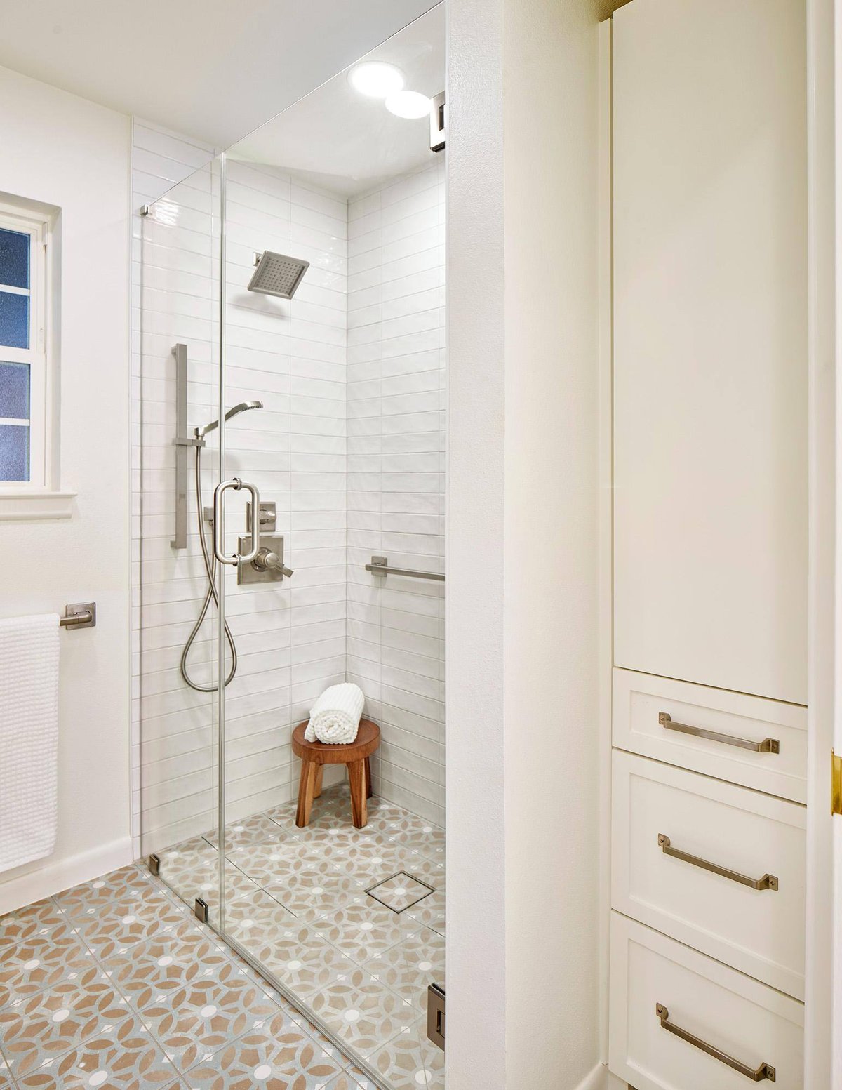 Walk-in shower with glass door and stylish tile flooring in a Sardone | McLain bathroom remodel in Dallas, TX