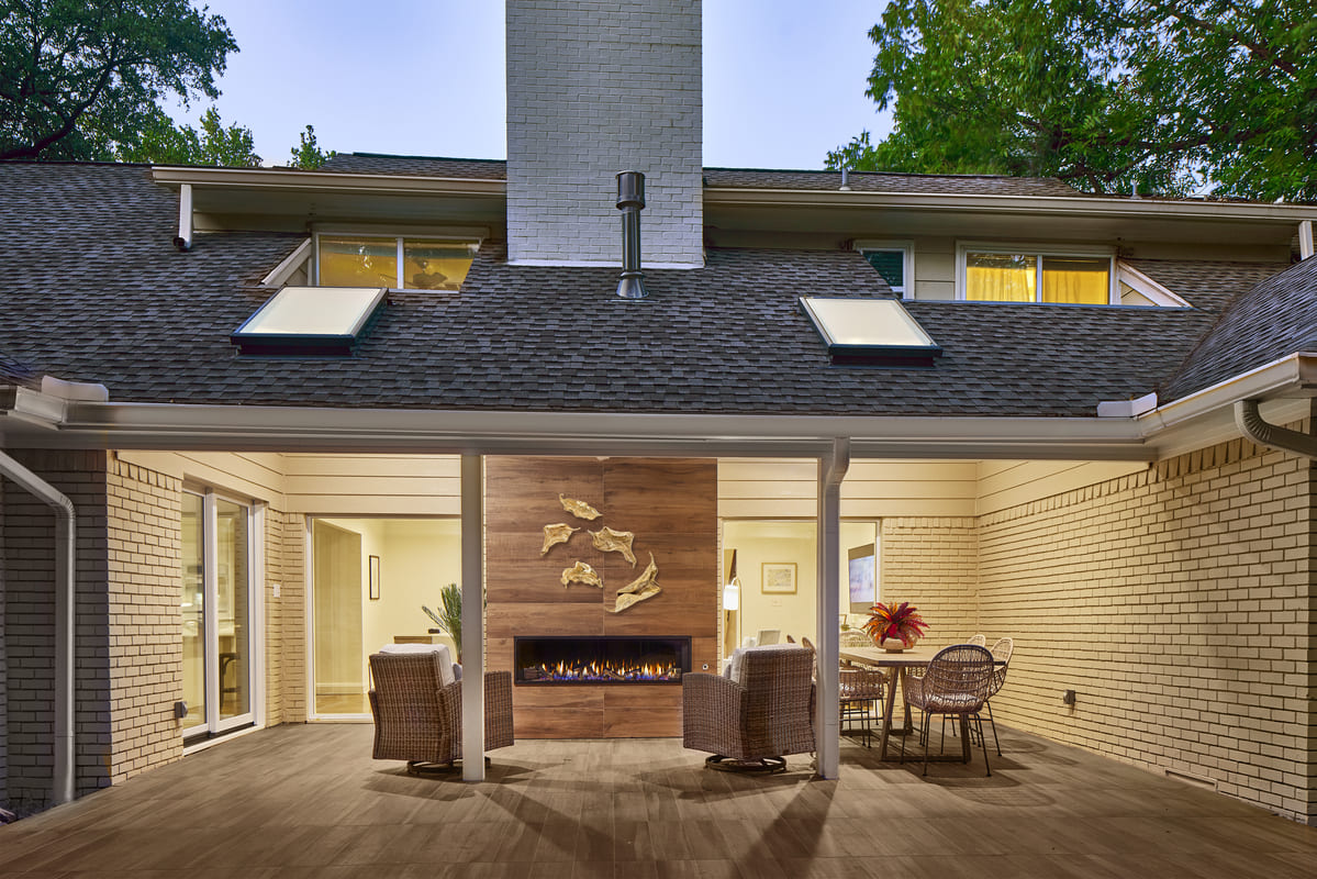 Exterior view of Dallas home remodel with covered deck and fireplace by Sardone | McLain