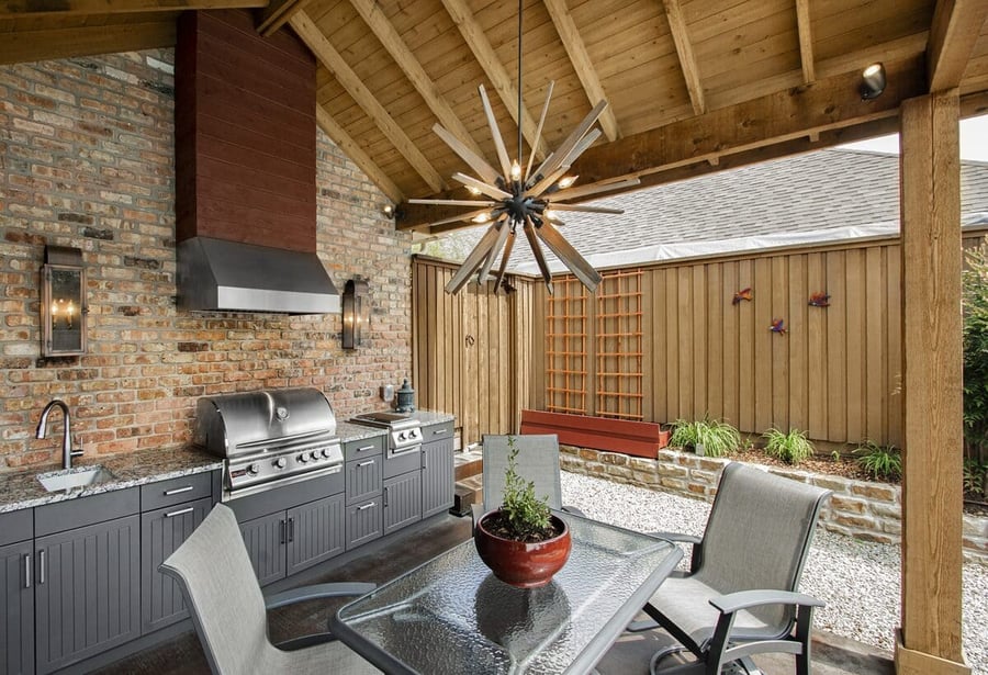 Covered outdoor kitchen with modern light fixture from vaulted roof by Sardone | McLain