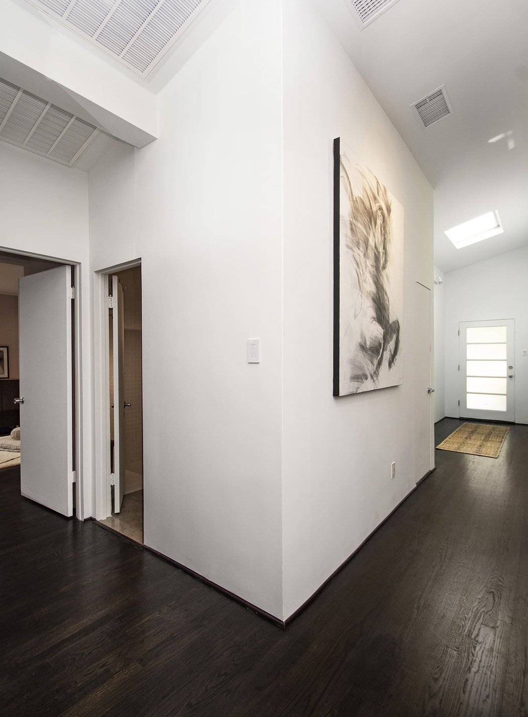 Hallway with wood flooring in Dallas, TX home remodel by Sardone | McLain