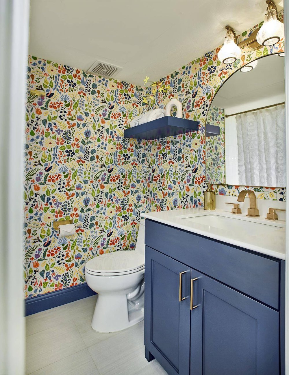 Bathroom with blue vanity and brass fixtures in Dallas townhome remodel by Sardone | McLain