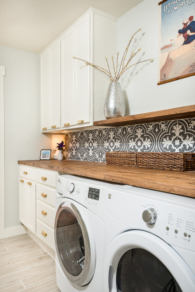 Washer and dryer in Dallas, Texas primary suite addition with mosaic backsplash and white cabinets