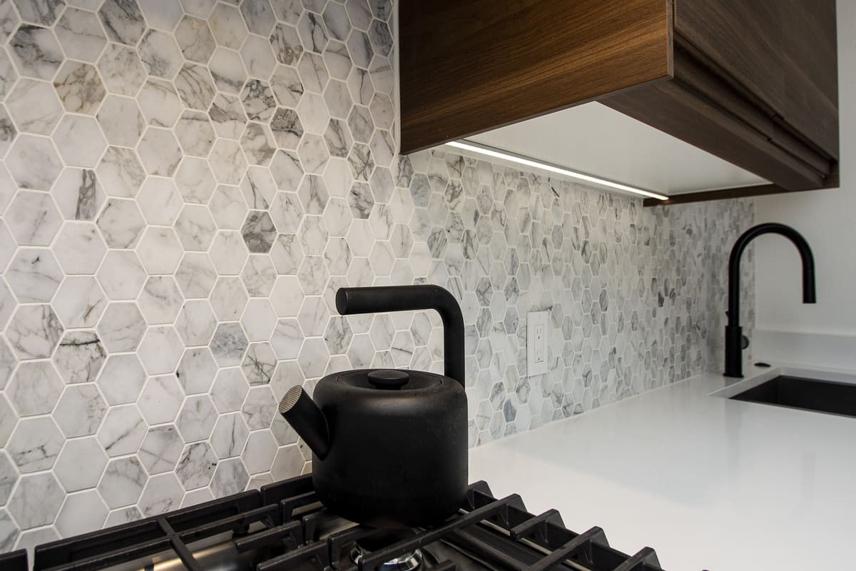 Task lighting above outlet in Dallas kitchen with hexagonal backsplash by Sardone | McLain